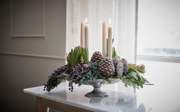 Klassisk adventskrans med fire hvide lys, gran og kogler