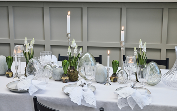 Påskefrokost med elegant borddækning, stearinlys og rolige farver