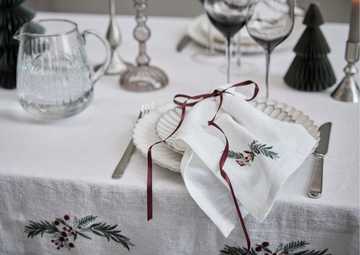 Smuk julebord med servietter, stel og juledug