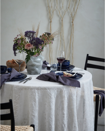 Romantisk valentinsmiddag på bordet med stearinlys, blomster og lækre retter – en perfekt måde at fejre kærligheden på